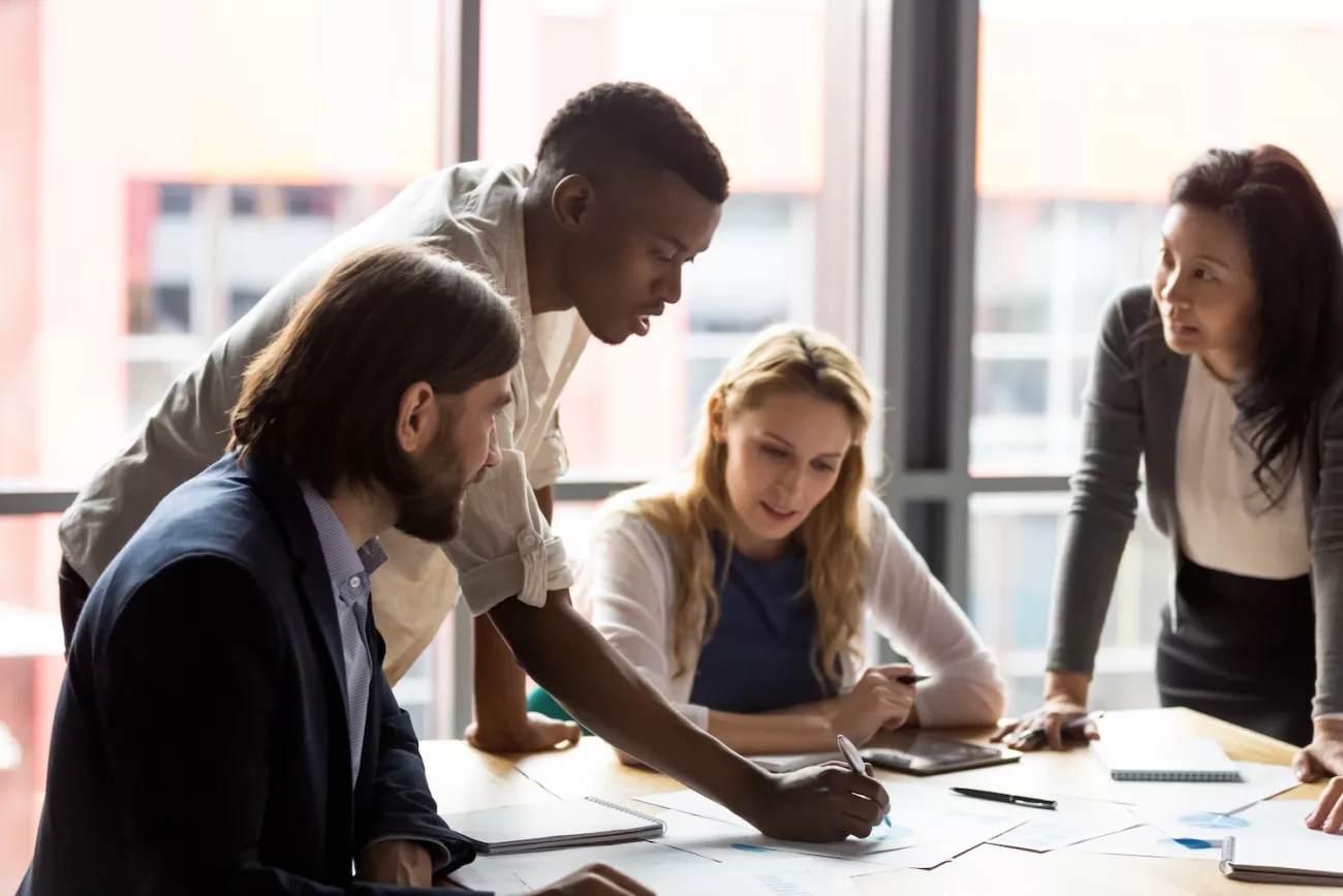 concentrated mixed race diverse colleagues developing marketing strategy in office